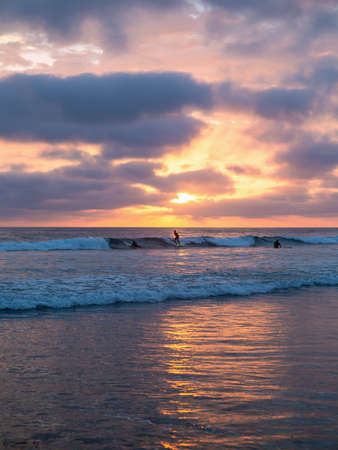 surfers at sunset at pacific beach