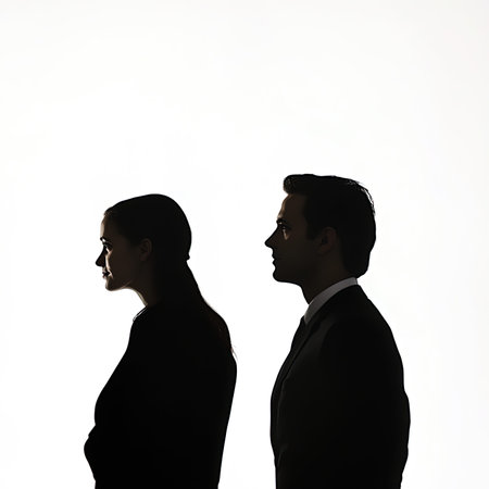 Silhouette of two people standing back to back isolated on white backgroundの写真素材