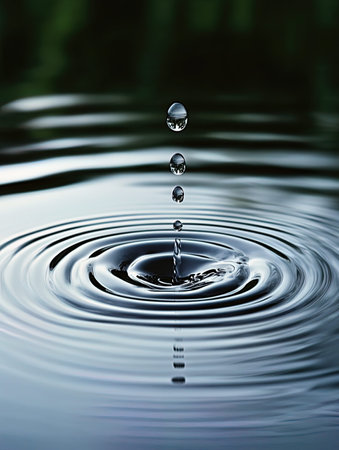 Water drop falling into the water with ripples and ripples.の写真素材