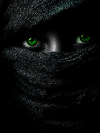 Close-up portrait of a woman with green eyes in a black scarfの写真素材
