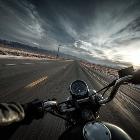 Motorcycle driving on a desert road at sunset with dramatic sky.の写真素材
