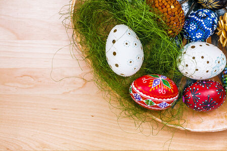 Top view of easter eggs in wooden bowl on wooden backgroud.