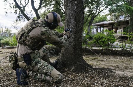 Soldier pointing his gun. USP gun. Airsoft player. Multicam camouflage. Mlitar in the woods. United States Navy. Airsoft guns. United States Navy. Soldier. Marine. Cutting weapon range. Airsoft.の写真素材