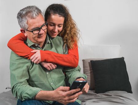 Father and daughter in each other's arms. Family having a video call. Father and daughter looking at...