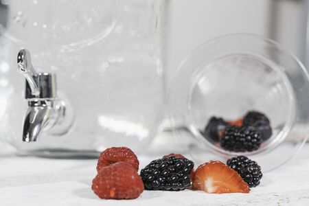 Flavored water. Bowl of red fruits. Raspberry. Strawberry. Blueberry. Fruits of the forest. Refreshing drink for the summer. Red fruits flavored water.の写真素材