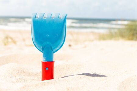 Rake at the Beach on a Sunny day. A vacation at the seashore. Sand all over the place. A sighing sound of the sea. Ready to build sand castles.の写真素材