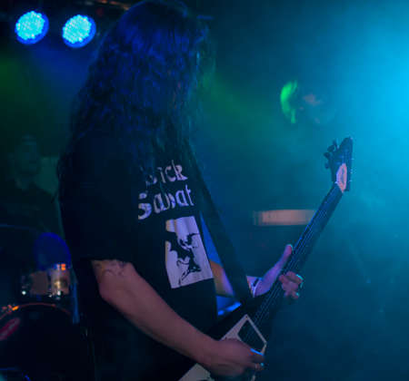 Guitarist playing the electric guitar during a solo show at a metal concert