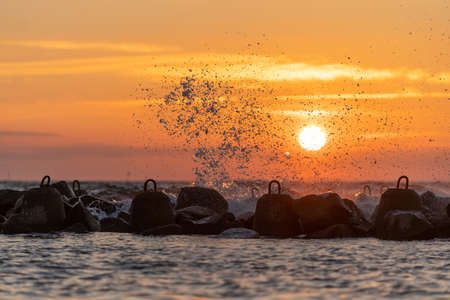 Sea waves crashing on the beach breakwater