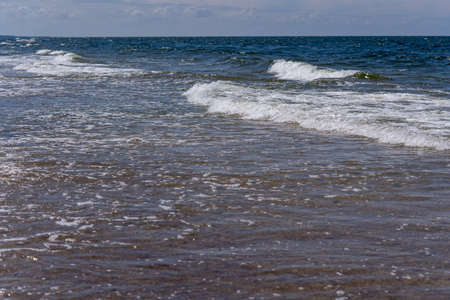 Foaming sea waves flowing to the shore