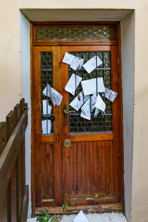 Old closed door to an abandoned house where the founding is being taken by the addressee of the letterの写真素材