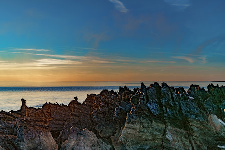 A beautiful shore, topped with sharp coastal rocks cutting the sea waves.