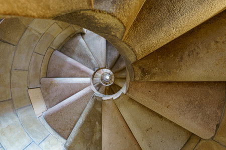 Old narrow stone circular staircase in an old buildingの写真素材