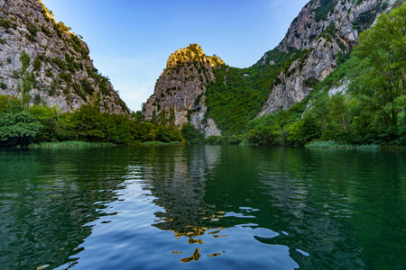 A view from the surface of a calm river towards its rocky banksの写真素材
