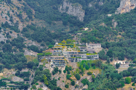 A beautifully integrated estate with glass windows into a mountainside covered with vegetationの写真素材