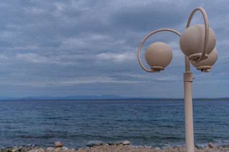 View of the seaside coastal beautiful lamps against the background of the sea and stormy skyの写真素材