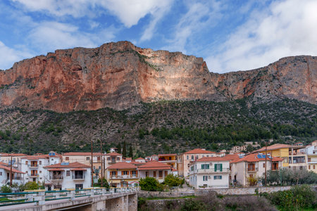 Beautiful view of a small town nestled beneath steep rocky mountainsの写真素材