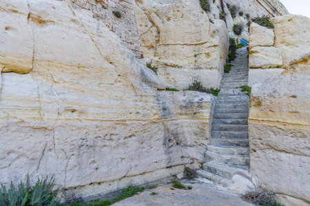 Narrow weathered steps carved in limestone, ascending between high rocks towards historic...