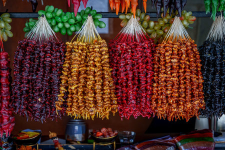 Rows of Georgian churchkhela nut sweets in rich colors hanging over bunches of fresh grapesの写真素材