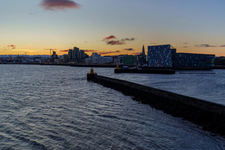 Reykjavik, Iceland - January 28, 2026: Harbor breakwater leads toward Harpa at sunset.のeditorial素材