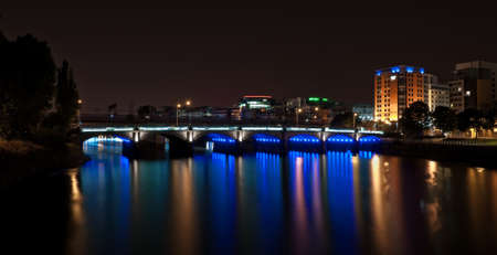 Blue bridge over the river at nightの写真素材