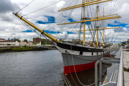 A sailboat standing in the port against the cloudy skyのeditorial素材