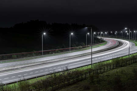 Highway at night with street lamps and carsの写真素材