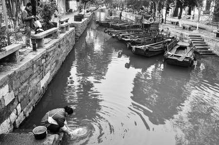Chinese woman washing her stuff in tongli river. China.のeditorial素材