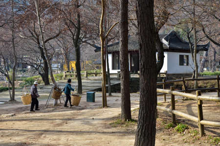 chinese couple carrying goods in old style way at sunny day in China.のeditorial素材