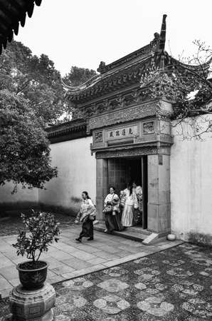 Chinese ladies walking through a gorgeous entrance. Tong-li, China.のeditorial素材