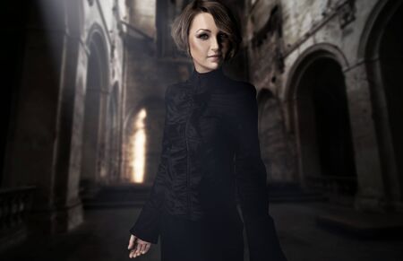 Beautiful young woman posing in a castle interior