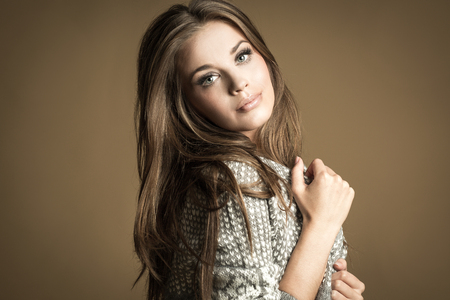 Beautiful Brunette Girl. Healthy Long Hair. Brown Backgroundの写真素材