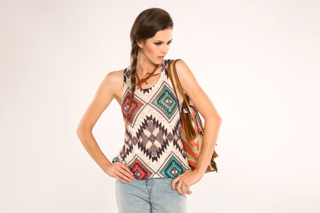 Brunette with linen orange bag with stipes standing on a gray backgroundの写真素材