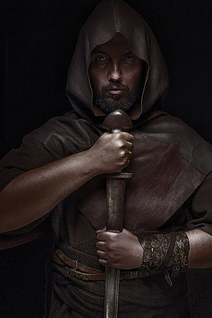Man dressed in barbarian style with sword and moustache, bearded screaming ready to fightの写真素材