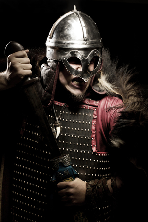 Shouting viking with sword and helmet over black backgroundの写真素材
