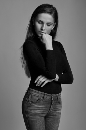 Nice looking young girl with long hair posing over gray backgroundの写真素材