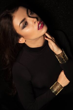 Portrait of beautifull brunette posing in studio over black backgroundの写真素材