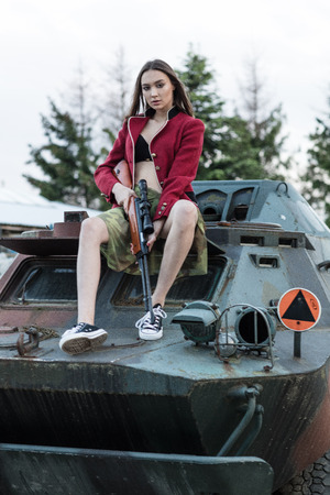 Charming model with the gun sitting on the tankの写真素材