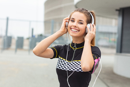 Attractive woman in sport clothes is exercising outdoors
