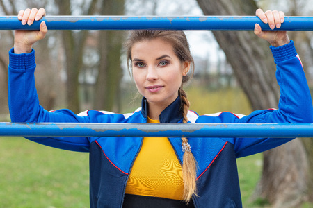 Attractive woman in  blue sport clothes is exercising outdoorsの写真素材