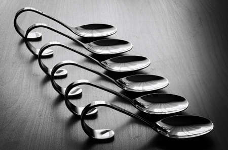 Evenly stacked teaspoons on the table.