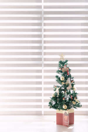 Christmas tree by the window with gift decorations for Christmas interiorの写真素材