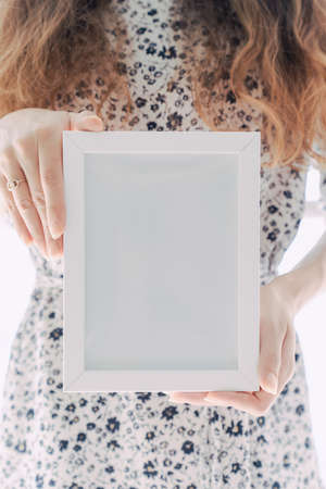 A woman's hand in a dress and holding an empty picture frameの写真素材