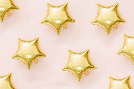 gold star shape balloon pattern on pink backgroundの写真素材