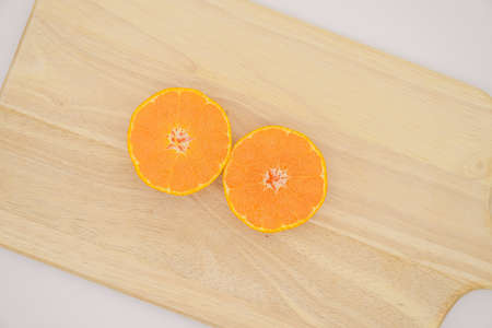 A cross section of a tangerine cut in half on a wooden boardの写真素材