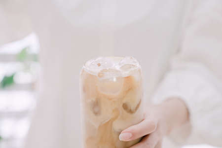 Woman's hand pouring milk to make caffe latteの写真素材