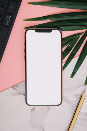 Mobile phone and pencil keyboard over pink and marble backgroundの写真素材