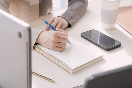 Working hands taking notes at office deskの写真素材
