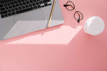 Laptop glasses coffee on a pink backgroundの写真素材