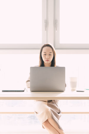 woman sitting at office desk and workingの写真素材