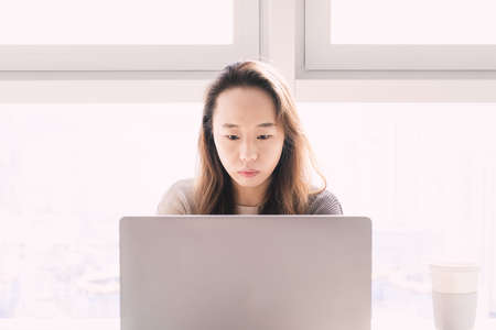 woman sitting at office desk and workingの写真素材